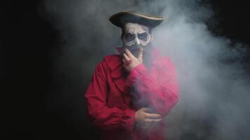 Man with long beard dressed up like a pirate for halloween over a black background with smoke coming out. video