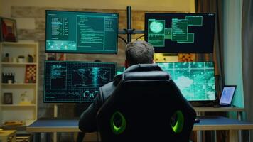 Hacker laying back on his chair while using powerfull computer to do cyber crimes. video