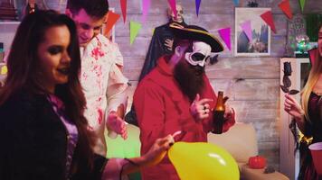 Crazy Halloween party with different funny and scary characters dancing in decorated room. Witch, repear, pirate and zombie video