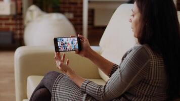 förvaltning verkställande använder sig av smartphone till delegera projekt uppgifter till anställda under videokonferens möte. chef på Hem innehav internet videosamtal på telefon med olika team video
