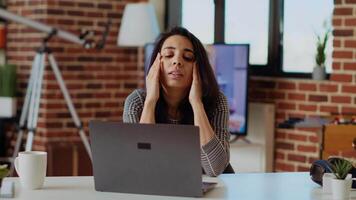 selbst beschäftigt Frau Gefühl krank, kämpfen zu konzentrieren während Arbeiten von heim, weh tun von Kopfschmerzen. erschöpft Freiberufler Leiden von Krankheit und Stress während Arbeiten auf Laptop, Kamera b video