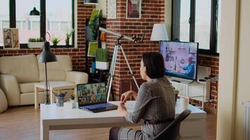 Teleworking management executive in apartment discussing with coworkers during videoconference meeting. Manager holding online videocall with remotely working employees, camera A video