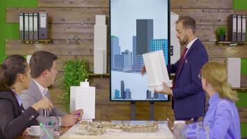 Architect in business suit holding a presentation about new building project. Architect holding building model. Mini town. video