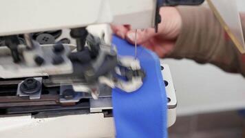 Female worker using industrial sewing machine for buttons in a fabric factory. video