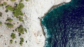 Drone flying over coastline with rocky clifs and deep blue sea water. video