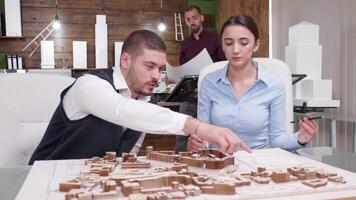 Team of architect working on big project for future town. Chief architect holding blueprint. video