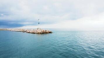 Drone flying over small lighthouse in the enterance of the port. video