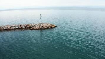 antenn Drönare antal fot av kust fyr nära de stad. skön turkos hav vatten. video