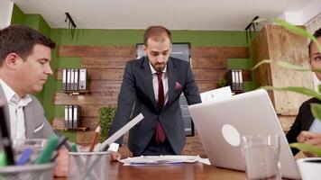 Man in business suit giving his colleagues statistics in the conference room. video