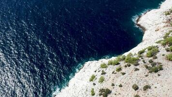 aéreo zumbido imágenes terminado rocoso costa línea y azul mar agua. rocoso costa. video