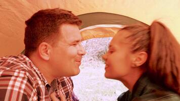 Inside view from a tent of boyfriend kissing his girlfriend forehead. Romantic couple. video