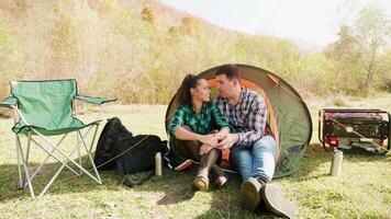 Attractive young couple cuddling in comfortable camping site near the mountains. video