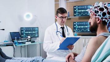 Doctor in a modern centre for neurology facility. Patient wearing brainwave scanning headset. video