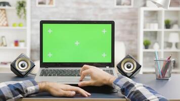 Mens handen scrollen Aan laptop met groen scherm geïsoleerd bespotten omhoog Scherm Bij dag in helder leven ruimte. pov schot video