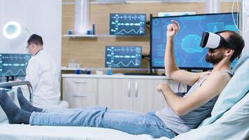 paziente seduta su ospedale letto indossare virtuale la realtà occhiali. moderno tecnologia per cervello ricerca. video