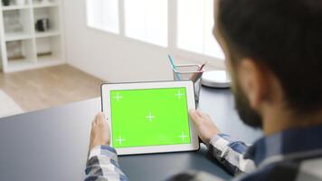 Man touching the green screen of a digital table PC in bright and well lit apartment video