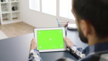 man rörande de grön skärm av en digital tabell pc i ljus och väl belyst lägenhet video