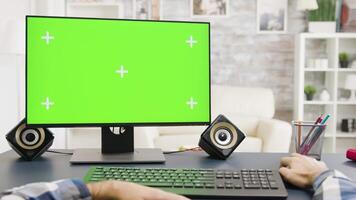 Male hands typing on green screen PC in bright and well lit living space. POV close up shot video