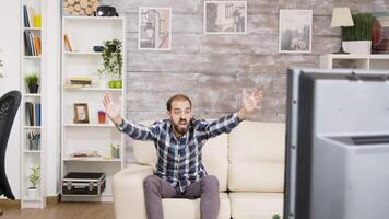 Bearded man angry because his favorite sport team lost. Watching tv and sitting on sofa. video