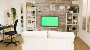 Big green screen tv in a cozy modern living space with big windows. video