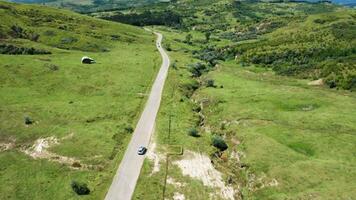 aéreo Visão Segue uma carro em rural estrada dentro lindo montanhas panorama video