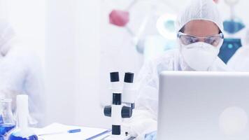 Chemical scientist using modern microscope in research laboratory. Scientist analysing a sample of blue solution on microscope. video