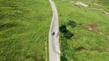 Top down view of car on rural road. Beautiful landscape. Drone footage video