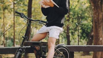 portrait de Beau souriant élégant branché lambersexuel modèle.homme habillé dans blanc T-shirt. mode Masculin équitation une bicyclette sur le rue Contexte dans des lunettes de soleil video