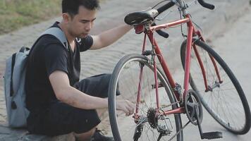 hombre sentado solo en el pico de el colina con bicicleta y tomando imagen de el ver video