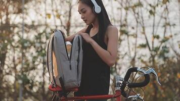 contento giovane asiatico donna mentre equitazione un' bicicletta nel un' città parco. lei sorrise utilizzando il bicicletta di trasporto. l'ambiente amichevole concetto. video