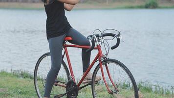 feliz jovem ásia mulher enquanto equitação uma bicicleta dentro uma cidade parque. ela sorriu usando a bicicleta do transporte. ambientalmente amigáveis conceito. video