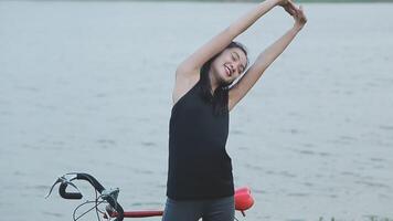 feliz jovem ásia mulher enquanto equitação uma bicicleta dentro uma cidade parque. ela sorriu usando a bicicleta do transporte. ambientalmente amigáveis conceito. video