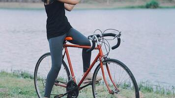 Happy young Asian woman while riding a bicycle in a city park. She smiled using the bicycle of transportation. Environmentally friendly concept. video