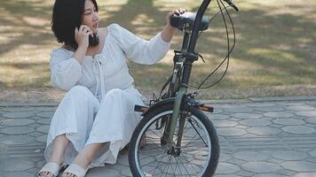 jolie Jeune femme sur vélo dans le ville rue, ville transport. Extérieur mode portrait de élégant blond frisé Dame équitation sa branché rétro bicyclette dans élégant bleu chandail. fille réparer salut. video