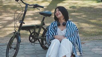 mooi jong vrouw Aan fiets in de stad straat, stad vervoer. buitenshuis mode portret van elegant blond gekruld dame rijden haar hipster retro fiets in elegant blauw trui. meisje fix hir. video