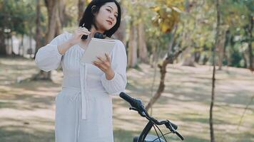 jolie Jeune femme sur vélo dans le ville rue, ville transport. Extérieur mode portrait de élégant blond frisé Dame équitation sa branché rétro bicyclette dans élégant bleu chandail. fille réparer salut. video