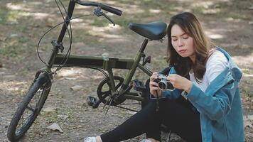 Happy Asian beautiful young woman riding bicycle on street outdoor near building city, Portrait of smiling female lifestyle using bike in summer travel means of transportation, ECO friendly video