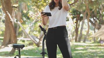 Happy Asian beautiful young woman riding bicycle on street outdoor near building city, Portrait of smiling female lifestyle using bike in summer travel means of transportation, ECO friendly video