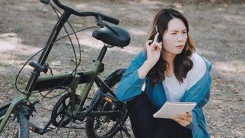 Happy Asian beautiful young woman riding bicycle on street outdoor near building city, Portrait of smiling female lifestyle using bike in summer travel means of transportation, ECO friendly video