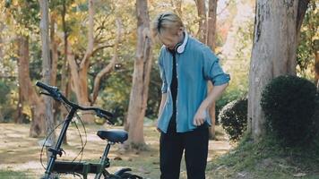 portrait de une content Jeune homme habillé dans chemise avec sac équitation sur une vélo en plein air video