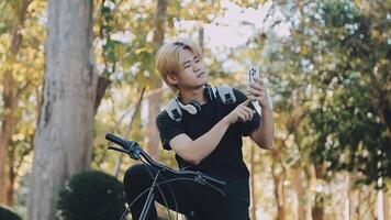 Portrait of a happy young man dressed in shirt with bag riding on a bicycle outdoors video