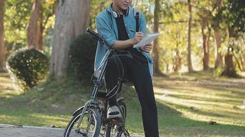 Porträt von ein glücklich jung Mann gekleidet im Hemd mit Tasche Reiten auf ein Fahrrad draußen video