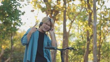 ritratto di un' contento giovane uomo vestito nel camicia con Borsa equitazione su un' bicicletta all'aperto video