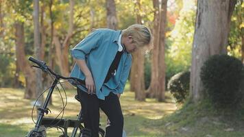 porträtt av en Lycklig ung man klädd i skjorta med väska ridning på en cykel utomhus video