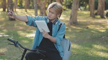 porträtt av en Lycklig ung man klädd i skjorta med väska ridning på en cykel utomhus video