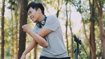 A handsome young man goes to the city with his bike. He is sitting on a bike and sending text message on the smartphone. video