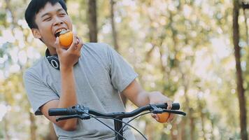 uma bonito jovem homem vai para a cidade com dele bicicleta. ele é sentado em uma bicicleta e enviando texto mensagem em a Smartphone. video