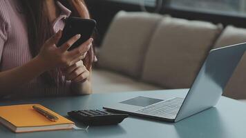 zakenvrouw hand werken met laptopcomputer, tablet en smartphone in modern kantoor met virtueel pictogram diagram op modernoffice in ochtendlicht video