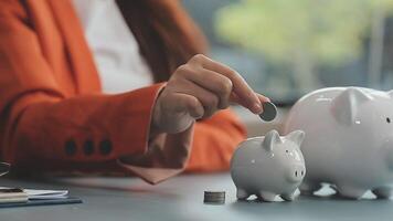 Female hand putting coin into piggy bank closeup video