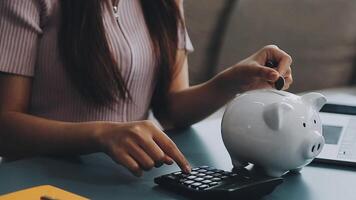 mujer poniendo moneda en cerdito banco, adentro video